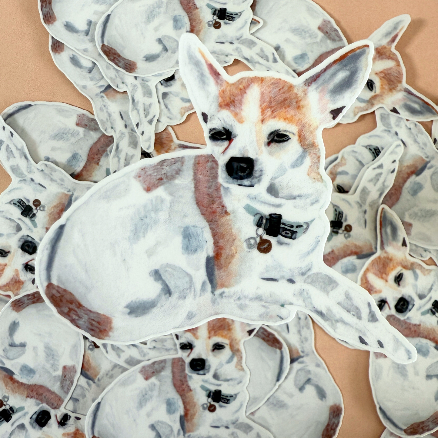 Picture of a die-cut sticker of a chihuahua surrounded by other die-cut stickers of the same design