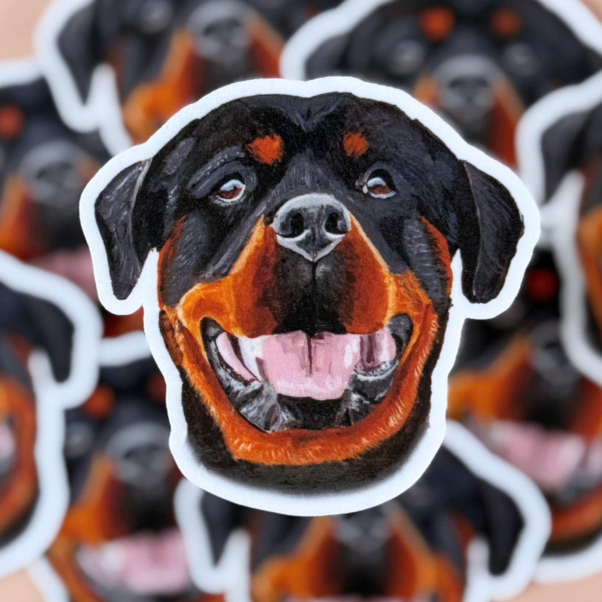 Sticker of a Rottweiler face with a white border with the same design sticker in the background