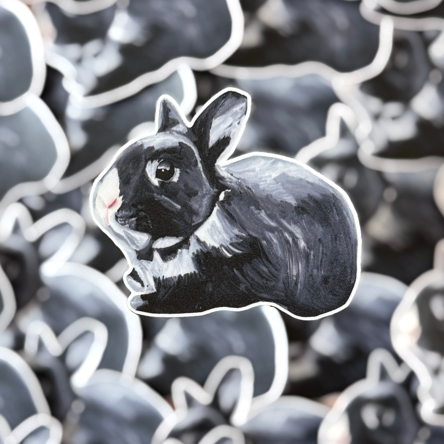 Black and white rabbit sticker with the same design stickers in the background